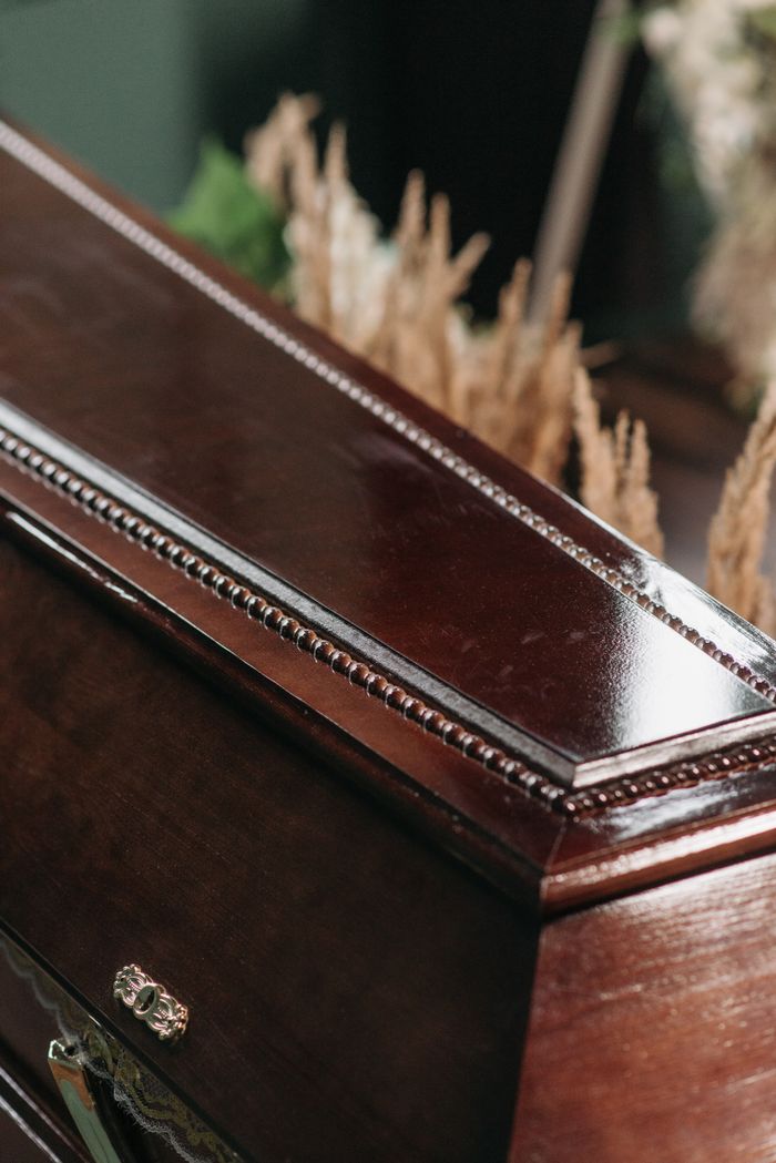 about-img Elegant wooden coffin reflecting the somber mood of a funeral ceremony.